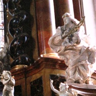Baroque altar with ornate carvings, angels, stained glass.