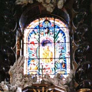 Baroque altar with ornate carvings, angels, stained glass.