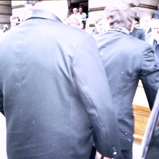 People entering a building through glass doors.