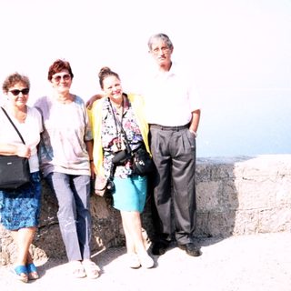 Four people posing together near a coastal cliff.