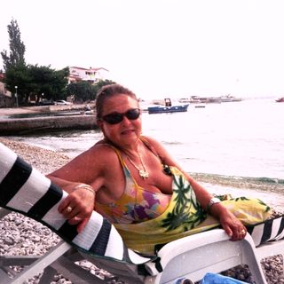 Woman relaxing on beach lounge by sea.