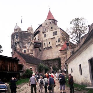 Medieval castle with tourists exploring historic grounds.