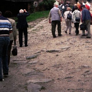 Medieval castle with tourists exploring historic grounds.