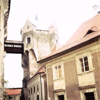 Medieval castle courtyard with stone buildings and tower.