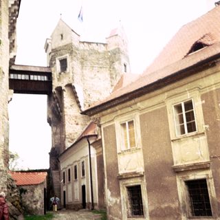Medieval castle courtyard with stone buildings and tower.