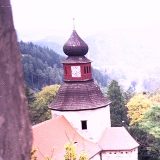 Historic castle tower overlooking forested valley.