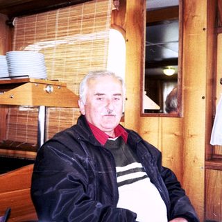 Man sitting indoors in a rustic restaurant setting.