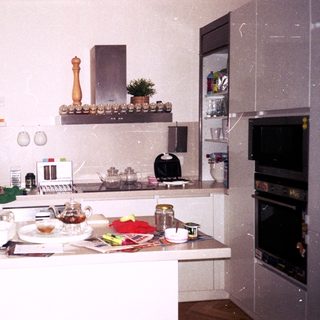 Vintage kitchen with cluttered countertops and appliances.