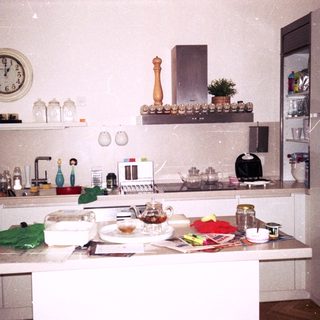 Vintage kitchen with cluttered countertops and appliances.