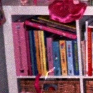 Playroom with colorful toys, bookshelf, playhouse, and seating.