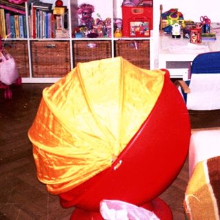 Playroom with colorful toys, bookshelf, playhouse, and seating.