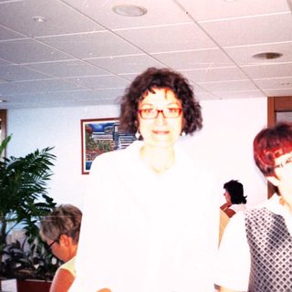 Two women posing indoors with cheerful expressions.