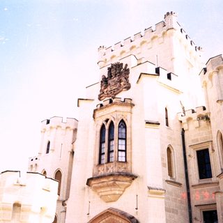 Medieval-style castle facade with heraldic crest.