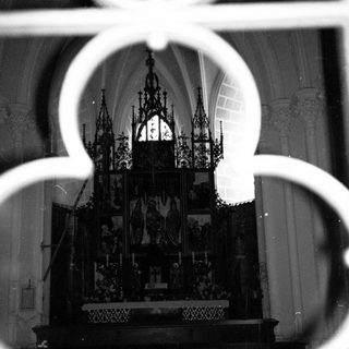 Gothic altar viewed through decorative iron grille.