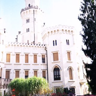 Grand historic castle with tall towers and gardens.