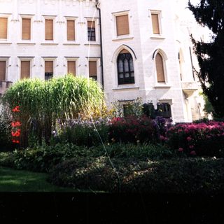 Grand historic castle with tall towers and gardens.