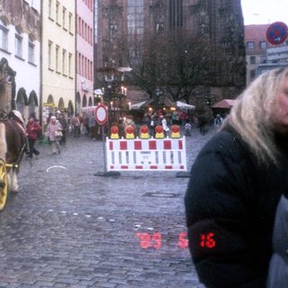 Historic horse-drawn carriage in European town square.