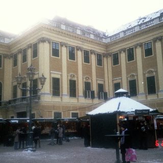 Winter market in courtyard of grand historic building.