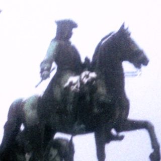 Equestrian monument with central seated figures and foggy background.