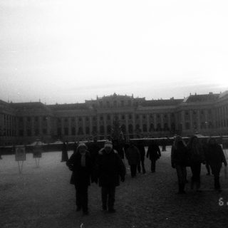 Winter scene at palace courtyard with people walking.