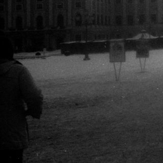 Winter scene at palace courtyard with people walking.