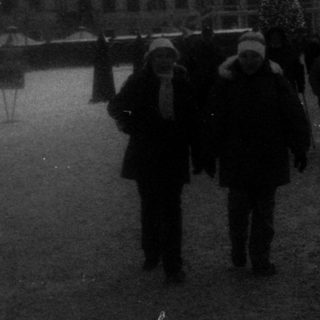 Winter scene at palace courtyard with people walking.