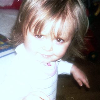 Young child sitting at table with toys.