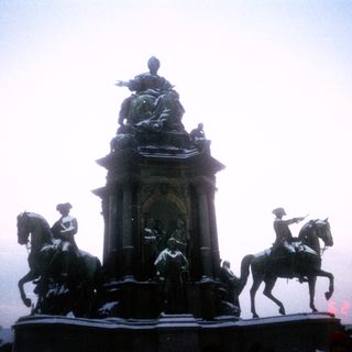 Equestrian monument with central figure atop pedestal.