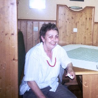 Two women sitting indoors in 1985, smiling at a table.