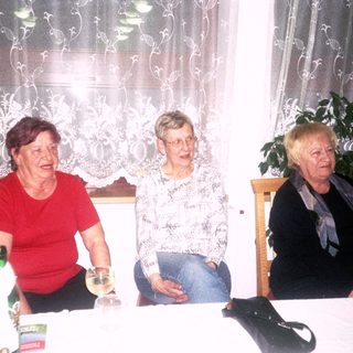 Three women sitting together indoors at a table.