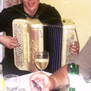 Three people enjoying a meal and music indoors.