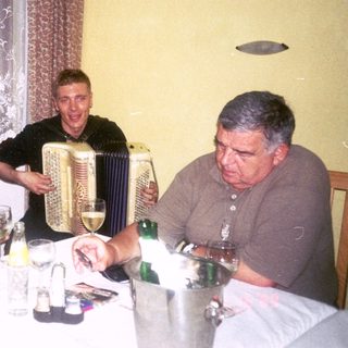 Three people enjoying a meal and music indoors.