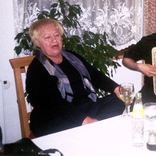 Three people enjoying a meal and music indoors.