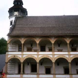Historic building with arched colonnade and clock tower.