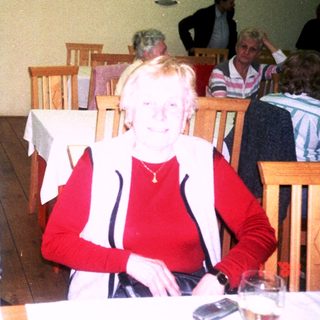 Two elderly women sitting together indoors at a café.