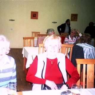 Two elderly women sitting together indoors at a café.