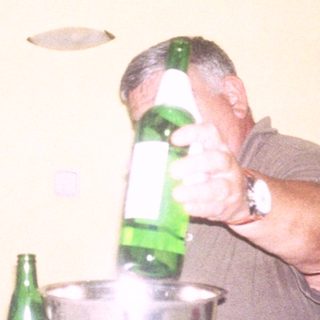 Two men enjoying drinks and music indoors.