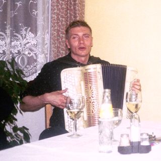 Two men enjoying drinks and music indoors.
