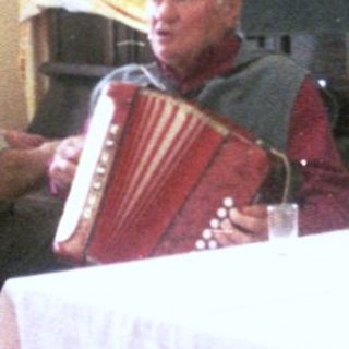 Group singing and playing accordion in classroom, 1983.