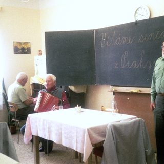 Group singing and playing accordion in classroom, 1983.