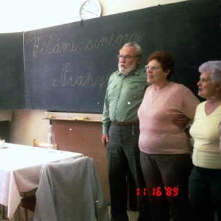Group singing and playing accordion in classroom, 1983.