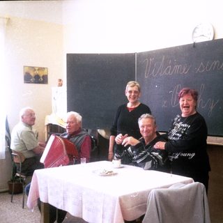 Group of seniors celebrating at event labeled "Viláme seniory."