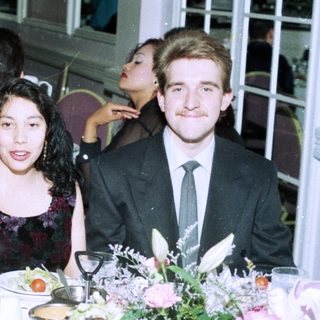 Formal event gathering with four people posing at a table.