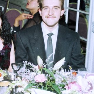 Formal event gathering with four people posing at a table.