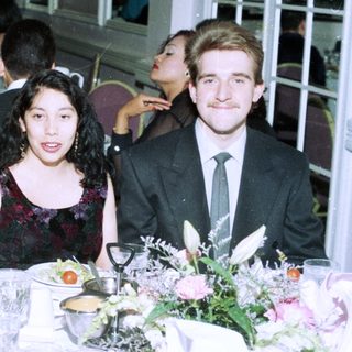 Formal event gathering with four people posing at a table.