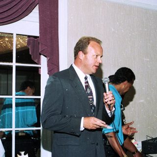 Men speaking at an indoor formal event.