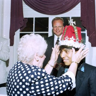 Ceremony crowning a man with a festive hat.