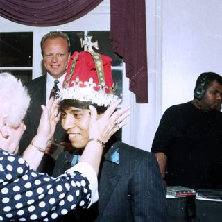 Ceremony crowning a man with a festive hat.