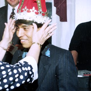 Ceremony crowning a man with a festive hat.