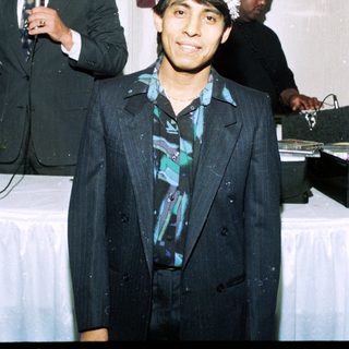 Man in formal suit wearing festive party hat.